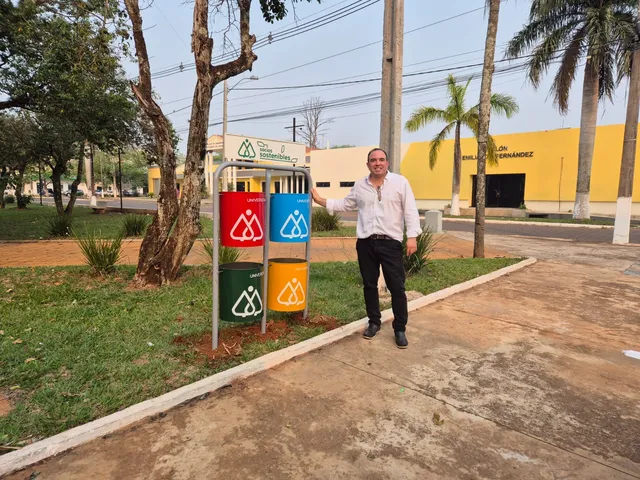 Nuevos basureros metálicos de alta resistencia instalados en una plaza pública con el logo de la Cooperativa Universitaria.